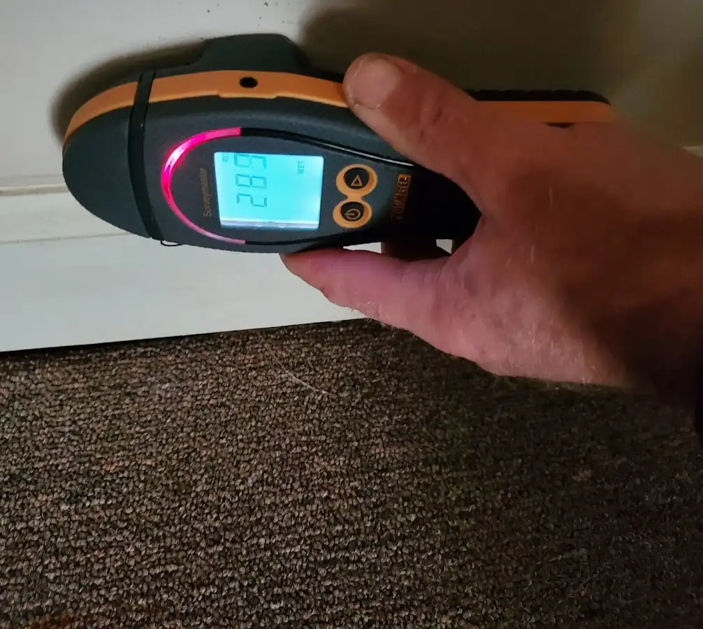 Moisture detection at baseboard during Storm Damage Restoration in Friendly